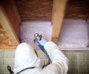 boxsills.jpg Worker installing insulation in basement rim joists and box sills.