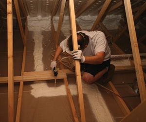 Worker air sealing a floor.