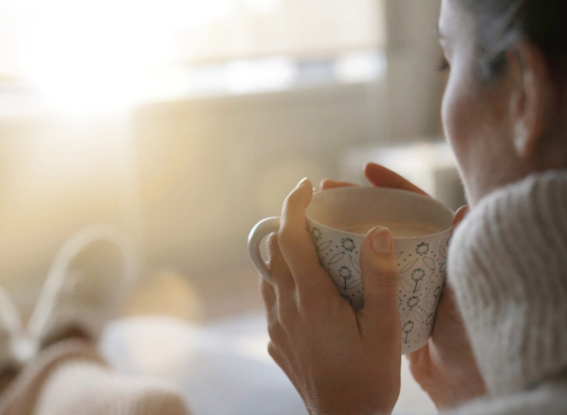 Woman sitting with a cosy cup staying warm