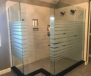Glass shower down with etched line pattern.