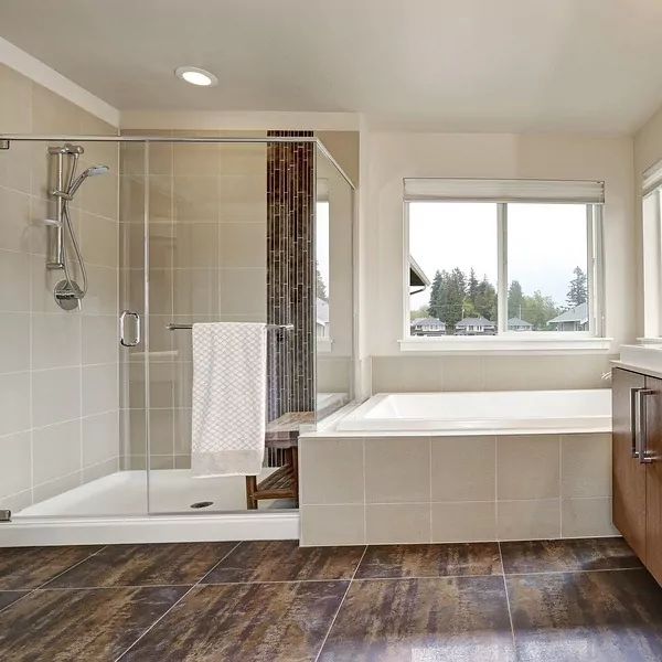 Slider shower doors and bathtub in a bright bathroom