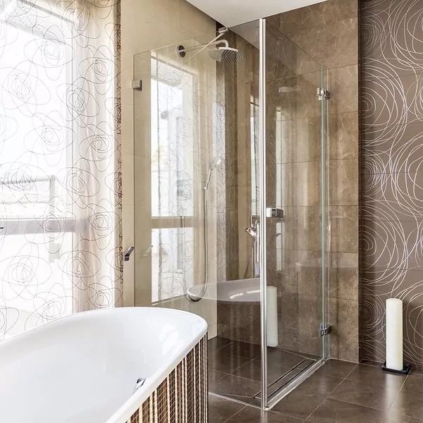 Hinged shower doors and bathtub in a bright bathroom