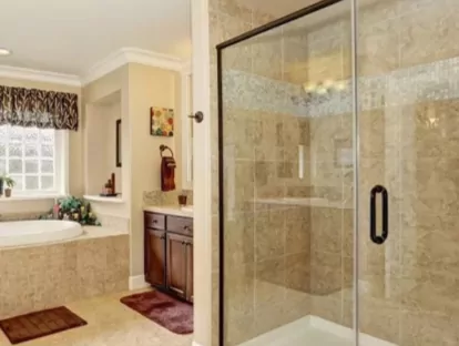 Glass shower doors in a large bathroom.
