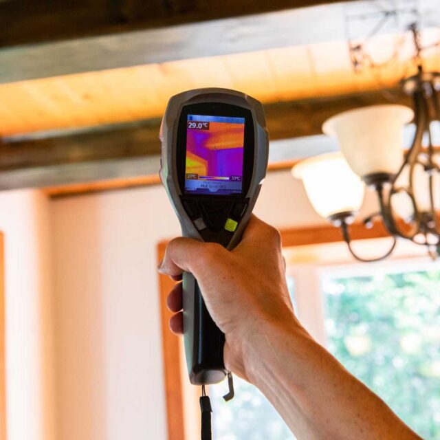 Hand-held infrared scanner in use to inspect insulation.