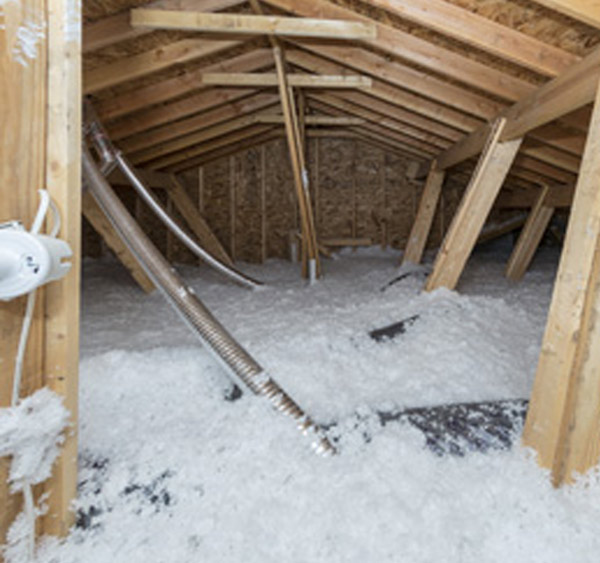 Close-up view of technician spraying blown-in insulation into attic ceiling cavity