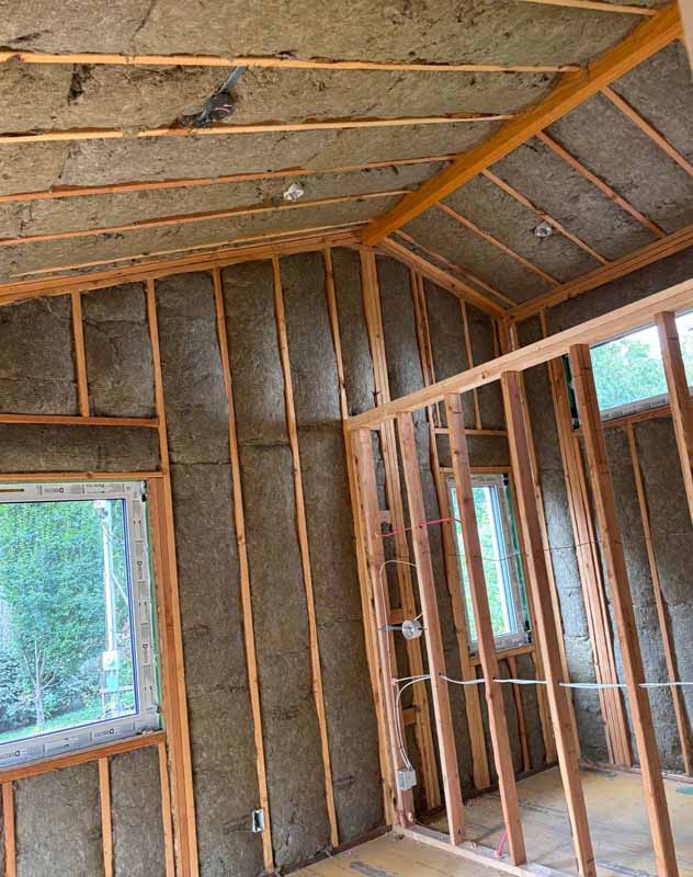 Framed residential interior with Rockwool mineral wool insulation installed in both walls and ceilings before drywall application.