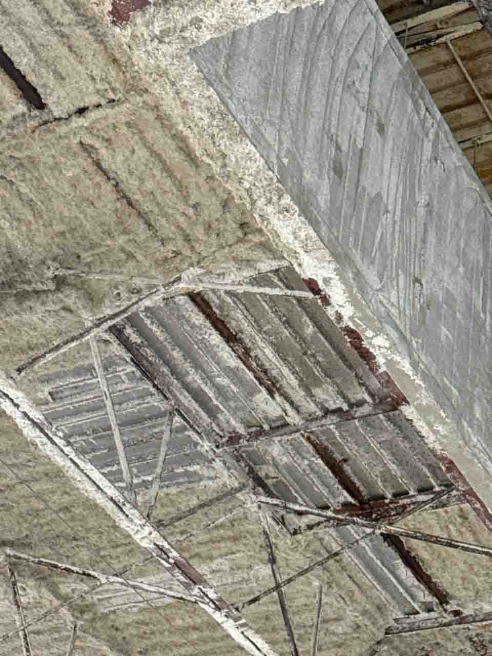 Close-up of partial spray foam application on a corrugated metal commercial ceiling deck.