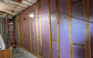 Wide-angle view of 1.5-inch foamboard insulation installed along an entire framed wall corridor with fiberglass batt ceiling insulation, 74 Broadway Kansas City project by Brinkmann Construction. Wide-angle view of 1.5-inch foamboard insulation installed along an entire framed wall corridor with fiberglass batt ceiling insulation, 74 Broadway Kansas City project by Brinkmann Construction.