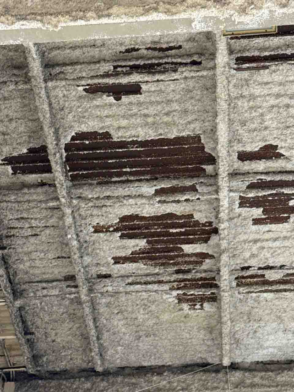 Close-up of partial spray foam application on a corrugated metal commercial ceiling deck.