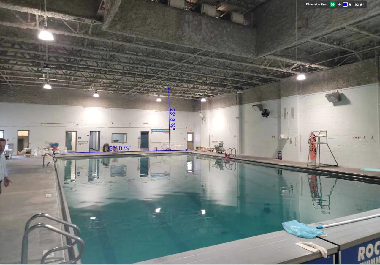 Indoor pool at Rockhurst High School natatorium before insulation with measurement overlay on ceiling.
