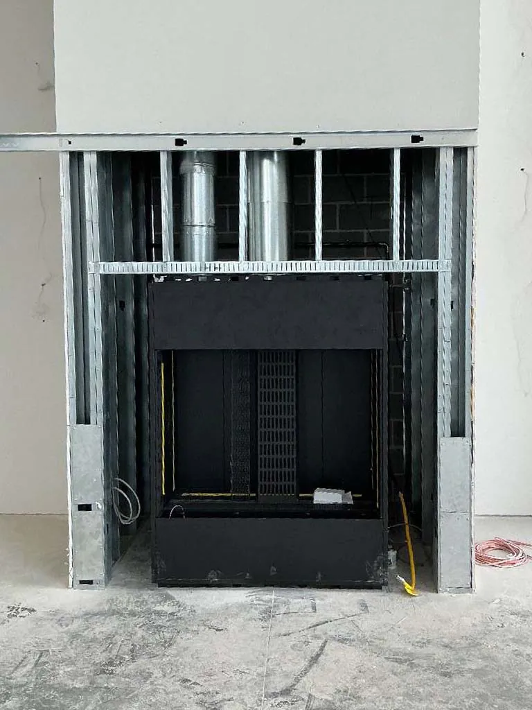 Montigo Prodigy 2 gas fireplace firebox set in steel stud framing with vent pipes connected above at Berkley Riverfront in Kansas City, MO.