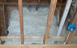 Close-up of open-cell spray foam insulation filling a rafter cavity in a vaulted ceiling in Kansas City, MO.