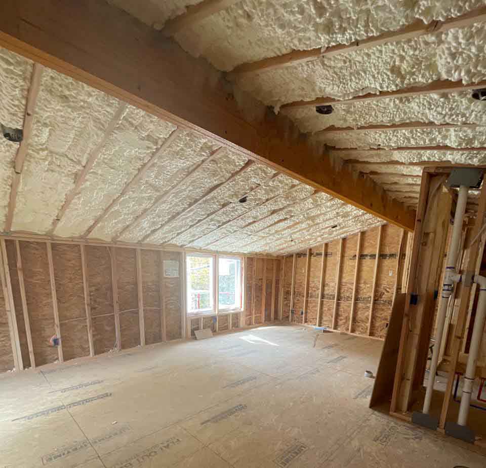Hayes Insulation KC open-cell spray foam insulation applied to the sloped roof rafters and flat ceiling of a new-construction bonus room in Kansas City, MO.